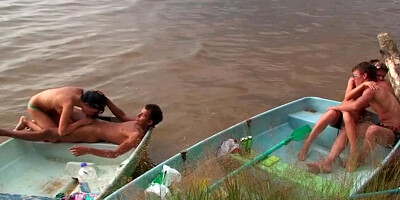 Horny people are having group sex on the beach in a small boat