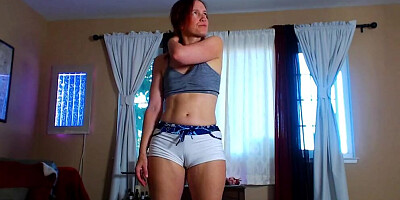 Redheaded chick is flexing and posing in front of the cam