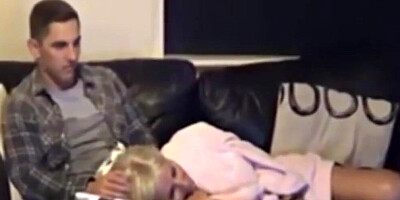 Blonde girl and her boyfriend are cuddling on the couch
