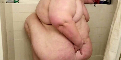 Huge woman is showing her naked body while having a shower