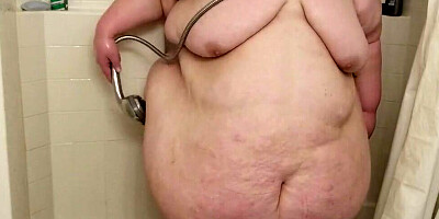 Huge woman is showing her naked body while having a shower