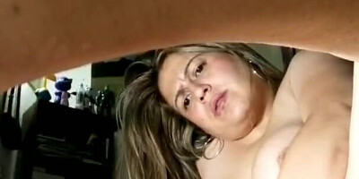 Chubby woman is spreading legs and ramming cunt with a cucumber