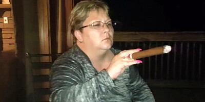 Amateur mature is smoking a cigarette in front of the camera