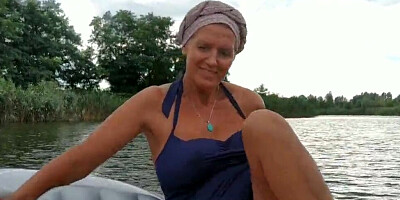 Mature lady paddles in that boat as her partner films her legs