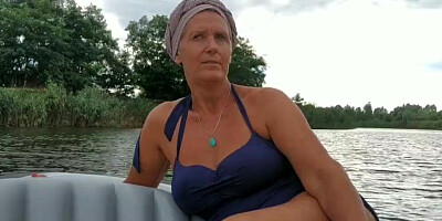 Mature lady paddles in that boat as her partner films her legs