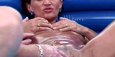 Oiled up MILF has her hungry pussy fisted by a dude outdoors