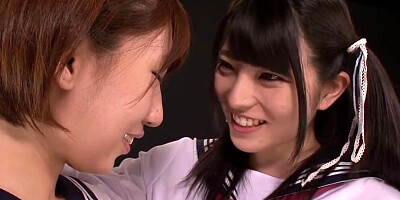 Two charming nerdy Asian schoolgirls are kissing and making out