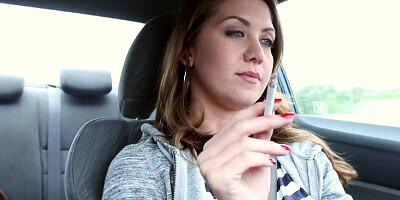 Chrissy Marie is smoking a cigar while driving a car