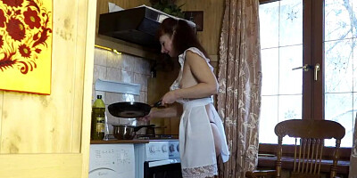 Lovely MILF is filmed while making a dinner in sexy dress