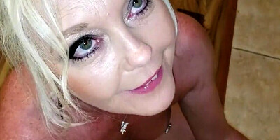 Blonde mom flirts with the camera while swallowing a big cock