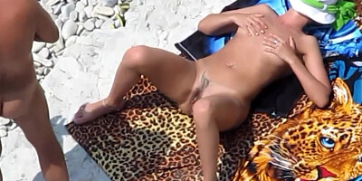 Mature couple is filmed while having genital interaction on a public beach