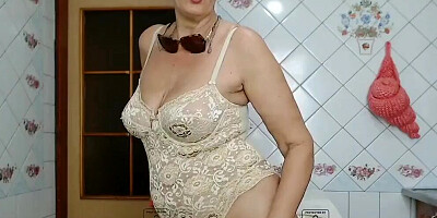 Elegant granny with big natural tits strips in front of the camera