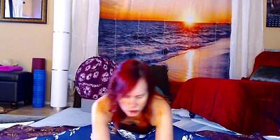 Redheaded chick is practicing some yoga in front of the cam