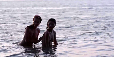 Two alluring girls are posing naked outdoors at a beach