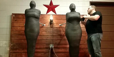 Two helpless girls are tightly wrapped and left to struggle