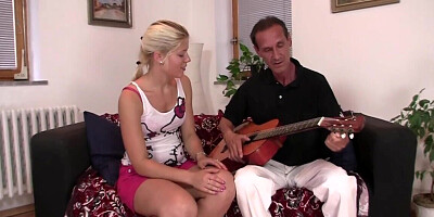 The older man plays the guitar to seduce her