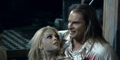 Two girls with serious looks in their faces are in a threesome