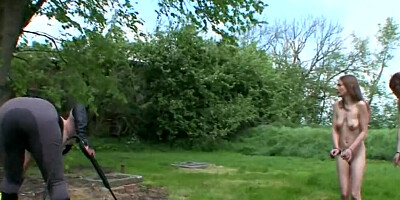 Two submissive girls are bound naked and flogged in the yard