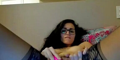 Sweet camgirl with glasses is wearing black stockings while enjoying pussy masturbation