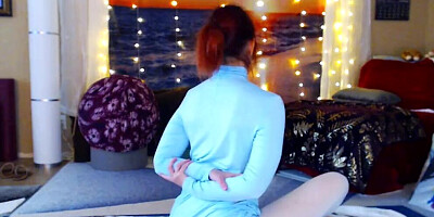 Redheaded babe is practicing yoga in front of the cam
