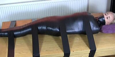 Secretary is being tightly roped and duct-taped by a kinky masked man
