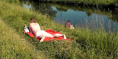 Nudist beach. Public nudity. Naked in public. Sexy MILF without panties and bra sunbathes naked Nude