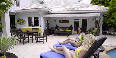 Two sex-craving girls are sharing a fat cock in a threesome next to a pool