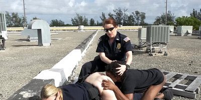 Black stud and two female cops are fucking on the roof