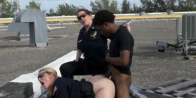 Black stud and two female cops are fucking on the roof